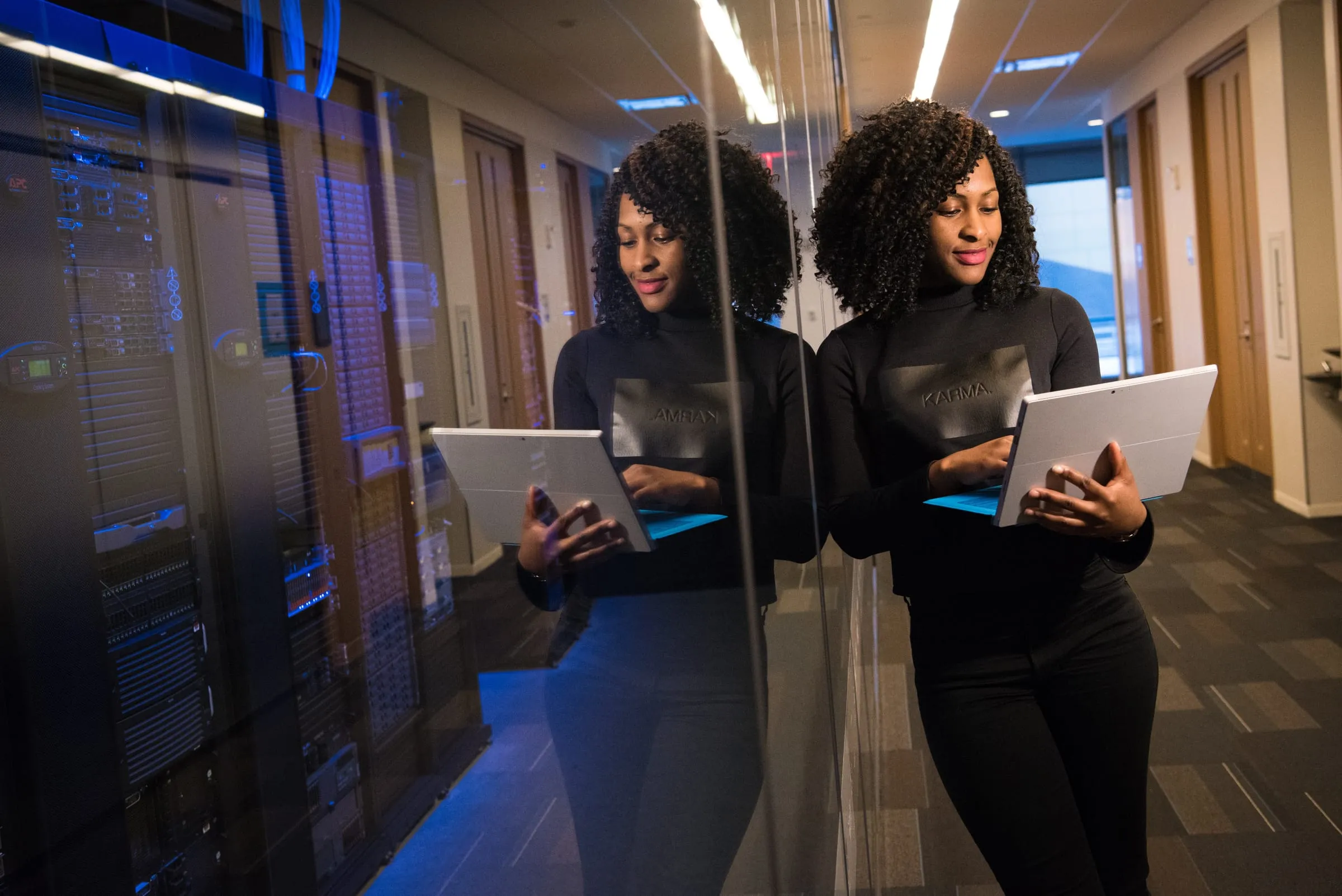 Two people with tablets in a server room